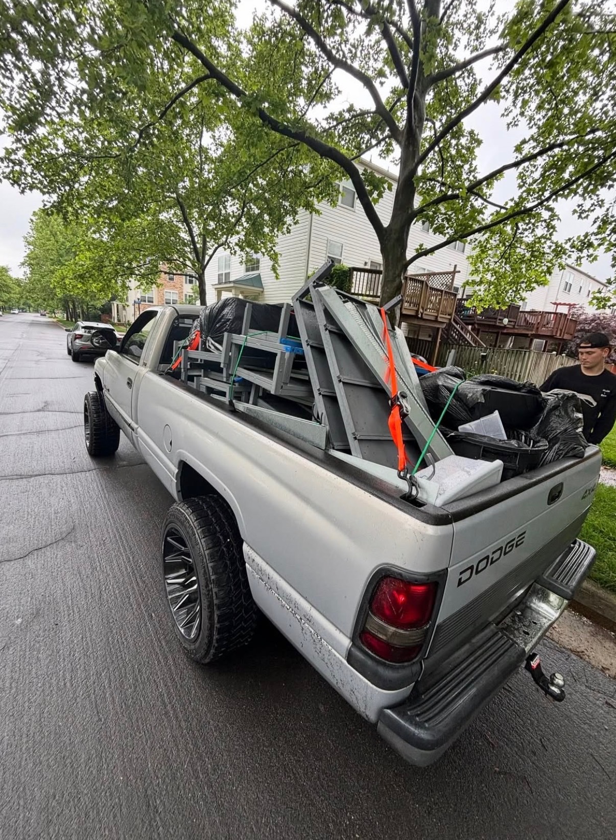 Hauling crew member beside a pickup loaded with furniture pieces and bags